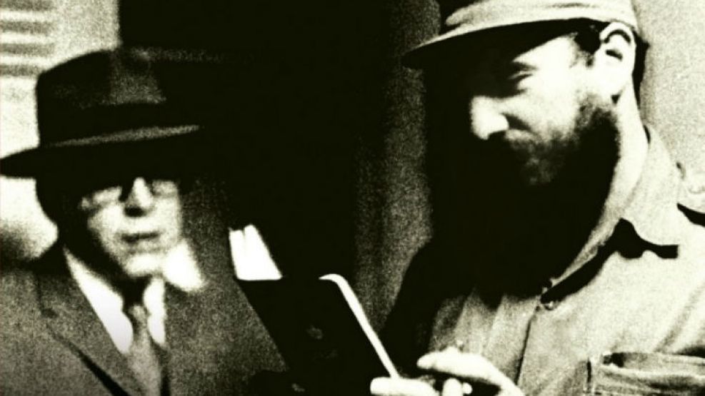 Cuba, marzo de 1965. Fidel Castro inspecciona con satisfacción el pasaporte falso de Ernesto “Che” Guevara, parado a su lado y ya transformado en Ramón Benítez.