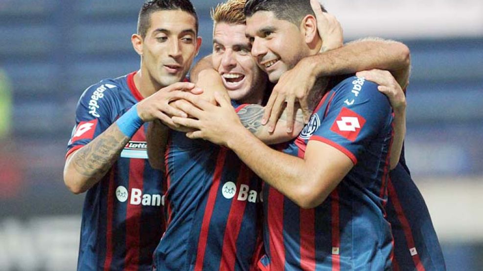 Unidos triunfaremos. Ortigoza, Buffarini y Verón festejan el primer gol del volante. San Lorenzo levantó su nivel antes de viajar.