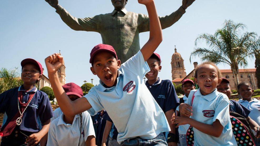 Amado. Decenas de niños bailan frente a la estatua de Madiba.