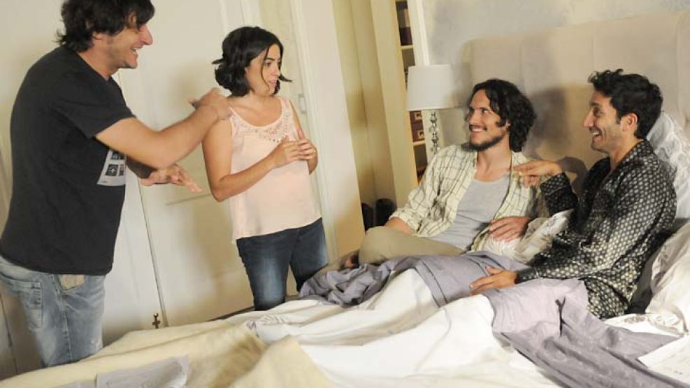 Trío. Sonrientes y en la cama, Juan Minujín y Sorini. El director les da indicaciones y Paola Barrientos escucha atenta. El jueves pasado, 11,5 puntos de rating.