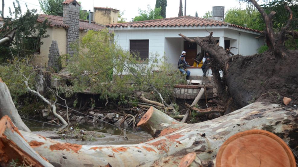 Destruccion. Hay cerca de 1.700 viviendas arruinadas (arr.). Los equipos de rescate buscaron durante días a Di Marco (der.).