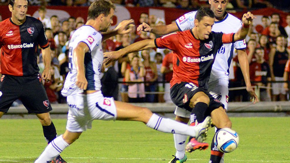 Es una lucha. Maxi Rodríguez intenta llevarse la pelota ante Joel Carli. Newell’s hizo todo el gasto, pero no pudo sumar tres puntos.