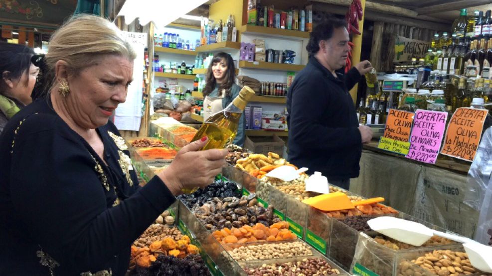 Carrió, evaluando un aceite de oliva durante una reciente recorrida al Mercado Central.