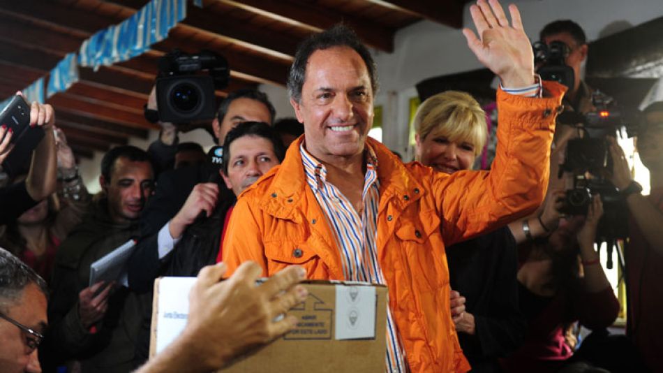 Scioli, de campera naranja, al emitir su voto.
