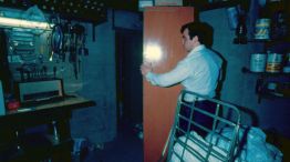 Archivo. En el sótano de la casona, un efectivo de la Policía bonaerense corre el armario para mostrar la estrecha puerta que conducía al sótano secundario, convertido en el 'calabozo'.