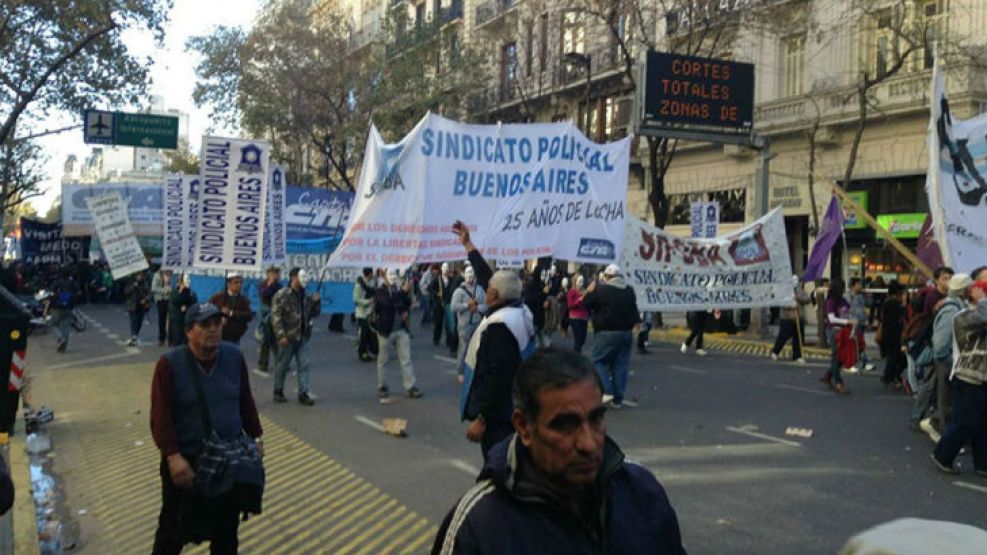 La protesta se movilizó por las calles de la ciudad de La Plata hasta la Gobernación bonaerense, donde colocaron cruces con gorras policiales, reiteraron los reclamos y lanzaron globos negros hacia el
