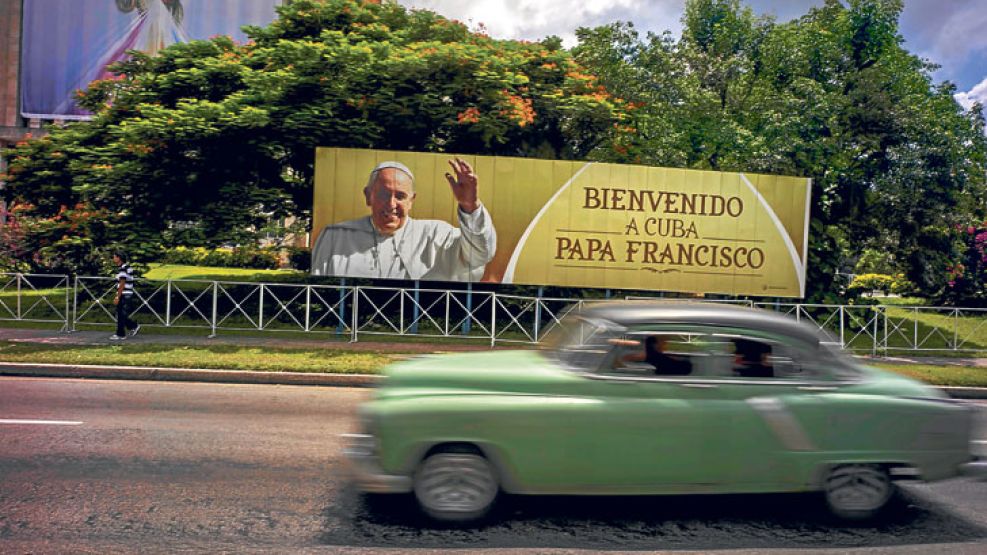 Espera. Un automóvil pasa frente a un cartel que saluda la llegada del Papa, en las calles de La Habana. El relieve del Che Guevara será el testigo principal de su homilía en una Plaza de la Revolució