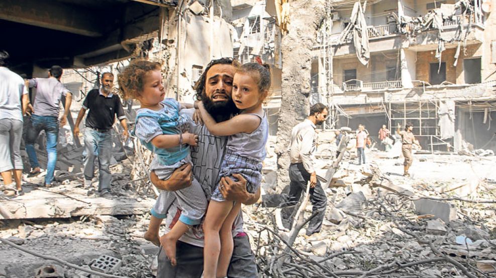 Victimas. Un hombre rescata a sus dos pequeñas hijas tras un bombardeo en la ciudad de Aleppo. 