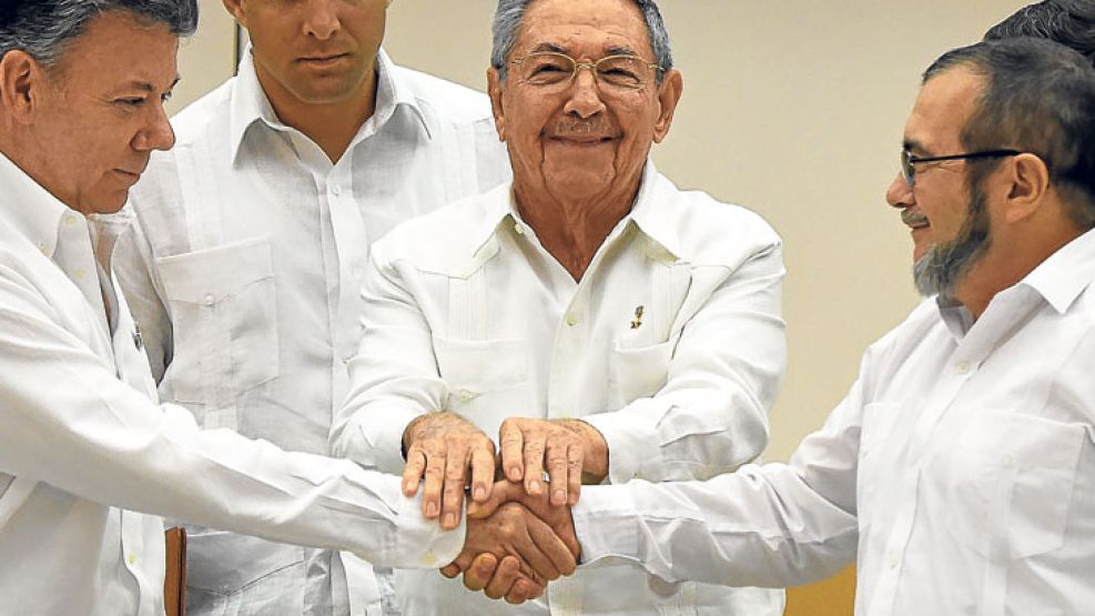 Gesto. El guerrillero Timochenko y Santos, en un apretón de manos ante Castro.