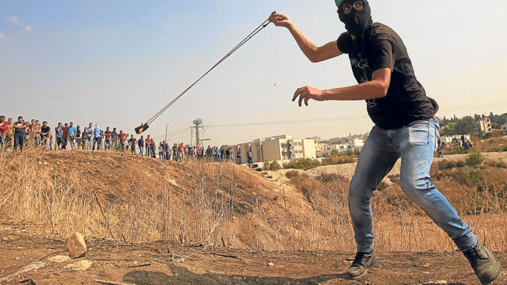 Violencia. Un partidario de Hamas lanza un proyectil en la Franja de Gaza. La ola de apuñalamientos alarma a Naciones Unidas. 