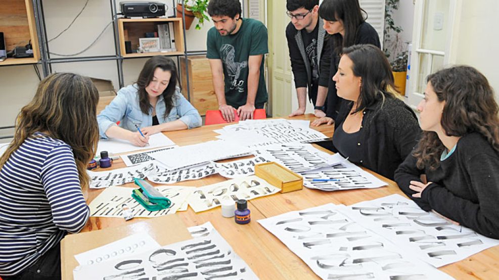 Estilos. Silvia Cordero Vega enseña trazos a sus alumnos en un espacio de Palermo (der.). Los trabajos incluyen desde caligrafía hasta letras dibujadas y composiciones tipográficas.