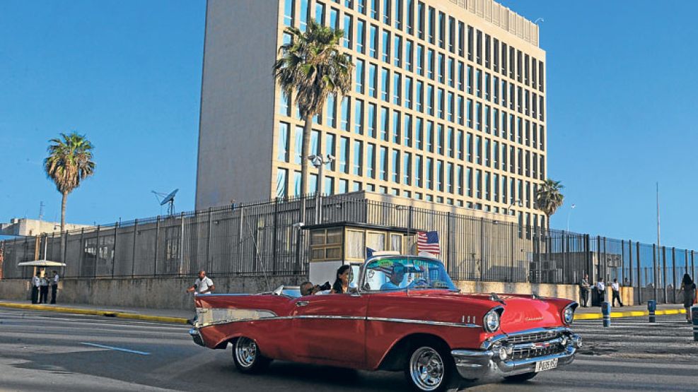 La Habana. Un tradicional botero circula frente a la Embajada de los Estados Unidos en la capital cubana. Postal de una nueva era.
