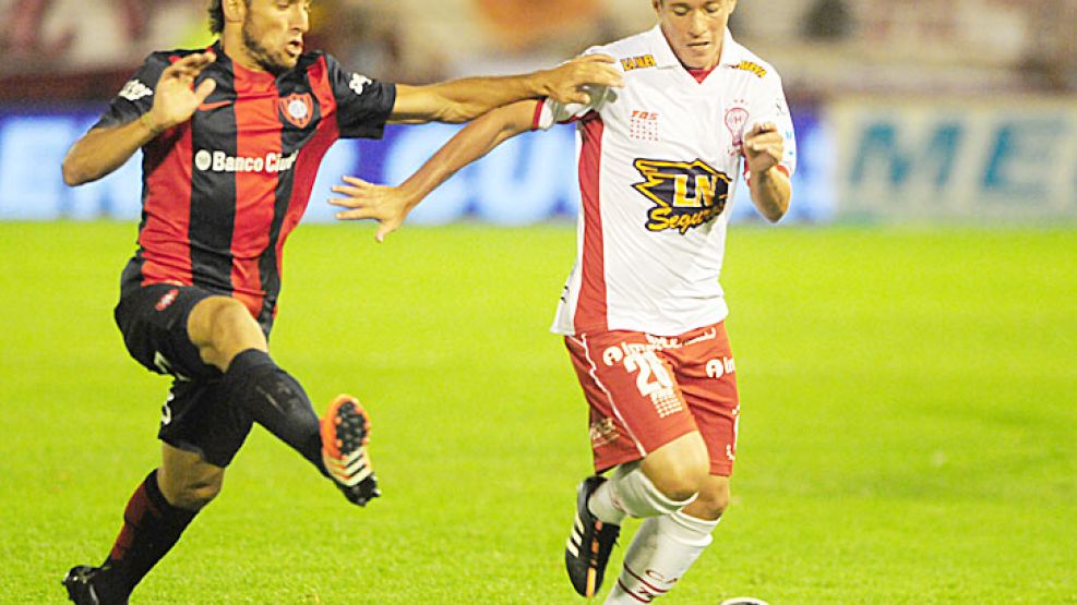 Rústico. Bogado controla la pelota, seguido de cerca por Belluschi.