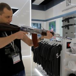 A salesperson demonstrates a model AK-47 assault rifle at the newly opened Gunmaker Kalashnikov souvenir store in Moscow's Sheremetyevo airport