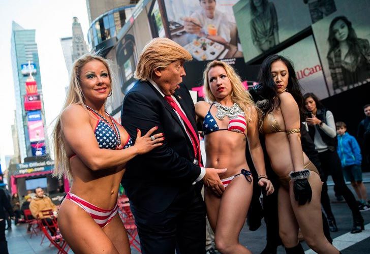 Un falso Trump rodeado de chicas en bikini.