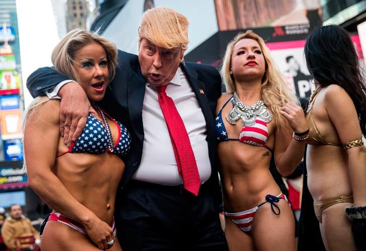 Un falso Trump rodeado de chicas en bikini.