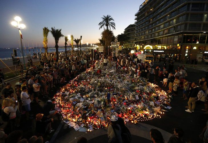 La gente se reúne en un monumento improvisado en la Promenade des Anglais en Niza el 17 de julio de 2016, en homenaje a las víctimas del ataque del Día de la Bastilla que dejó 84 muertos.