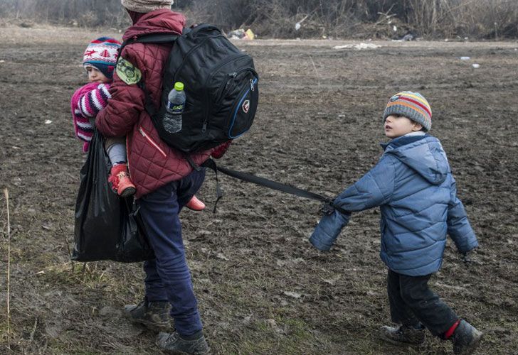 Un niño atado con su madre camina con otros migrantes y refugiados después de cruzar la frontera macedonia en Serbia, cerca del pueblo de Miratovac, el 29 de enero de 2016.