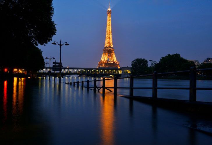 Una foto tomada el 5 de junio de 2016 en la noche muestra la torre Eiffel iluminada en frente del río Sena en frente Beaugrenelle en París.