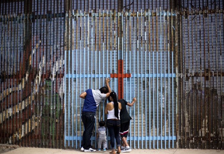 Una familia conversa con familiares a través de la valla fronteriza México - Estados Unidos en Playas de Tijuana, en Tijuana, noroeste de México, el 2 de julio de 2016.