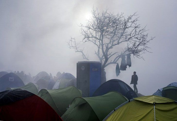 Un muchacho se coloca entre tiendas durante una mañana brumosa en un campo improvisado en la frontera Griego-Macedonia cerca del pueblo griego de Idomeni el 8 de marzo de 2016.