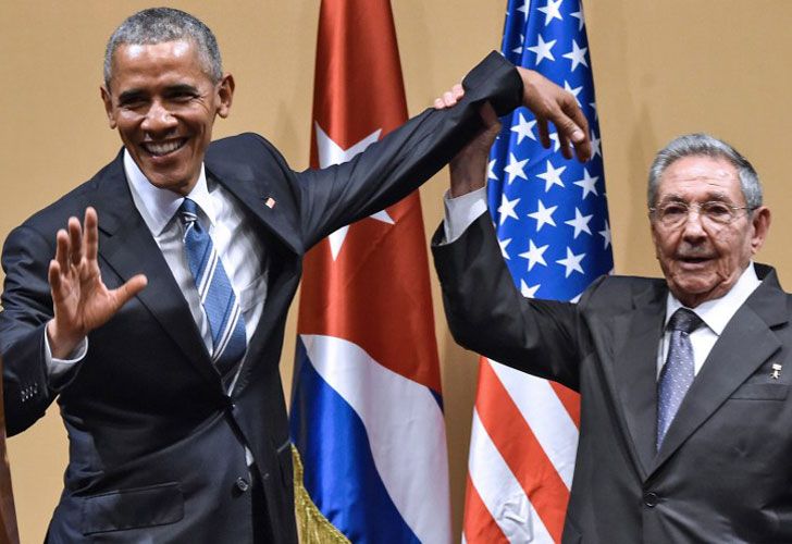 El presidente cubano Raúl Castro (R) levanta la mano del presidente estadounidense Barack Obama durante una reunión en el Palacio de la Revolución en La Habana, el 21 de marzo de 2016.