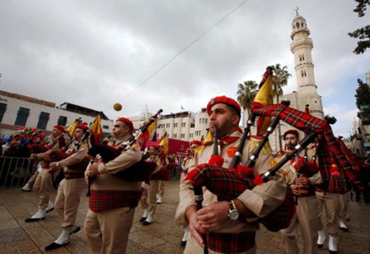 Los exploradores cristianos palestinos se realizan en el cuadrado del pesebre fuera de la iglesia de la natividad mientras que la gente se reúne para las celebraciones de la Navidad en la ciudad de Belén en la Cisjordania ocupada por Israel, el 24 de diciembre de 2016.