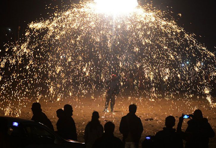 Los devotos cristianos indios ven una demostración de los fuegos artificiales que marca la Nochebuena fuera de la iglesia de San Pedro en Allahabad el 24 de diciembre de 2016.