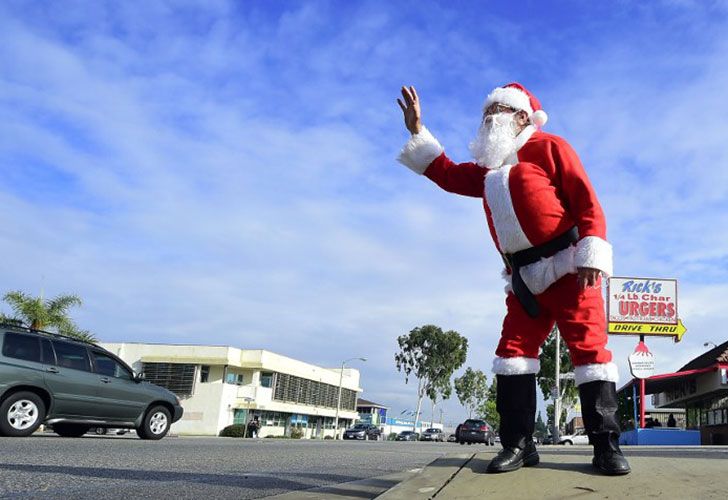 Charles Walker, de 73 años, ofrece un poco de alegría festiva a la gente en los coches que pasan el 22 de diciembre de 2016 en Rosemead, California, cerca de donde duerme con sus pertenencias en su coche. Esta temporada de Navidad, como lo ha hecho durante los últimos años, Taylor se pone el traje de Santa prestado de un amigo que posee el restaurante cercano, que también le ofrece comida cuando tiene hambre.