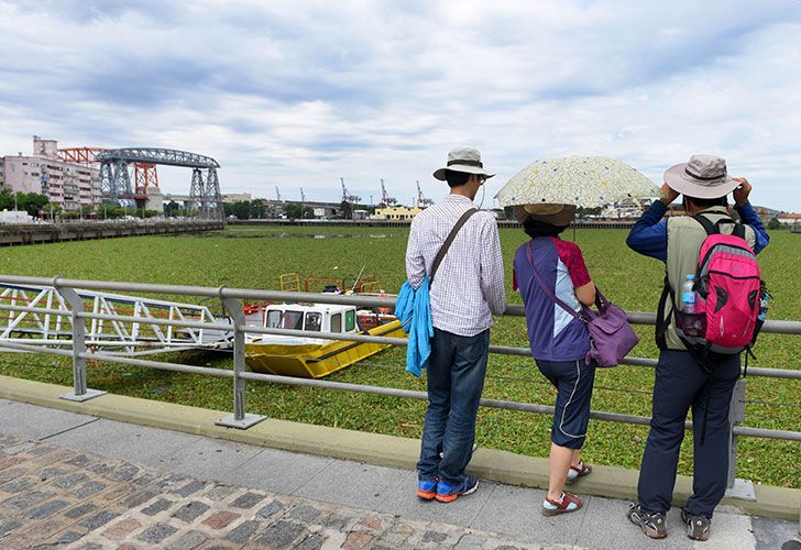 Turistas en La Vuelta de Rocha,  Barrio de La Boca, observan los camalotes que cubren las aguas del Riachuelo tras una inusual crecida del Río Paraná. 