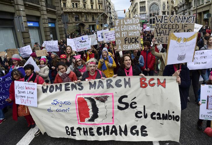 La gente marcha sosteniendo carteles en el centro de Barcelona el 21 de enero de 2017 en una marca de solidaridad para el mitin político que promueve los derechos y la igualdad para las mujeres, Marcha de la Mujer en Washington, que tiene lugar hoy en la capital de EE.UU.