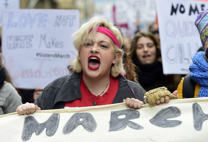 La gente marcha sosteniendo carteles en el centro de Barcelona el 21 de enero de 2017 en una marca de solidaridad para el mitin político que promueve los derechos y la igualdad para las mujeres, Marcha de la Mujer en Washington, que tiene lugar hoy en la capital de EE.UU.