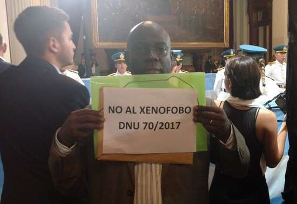 El cartel del congolés Nengumbi Celestin Sukama, que se mostró en contra del decreto que quiere regular el ingreso de inmigrantes a Argentina.