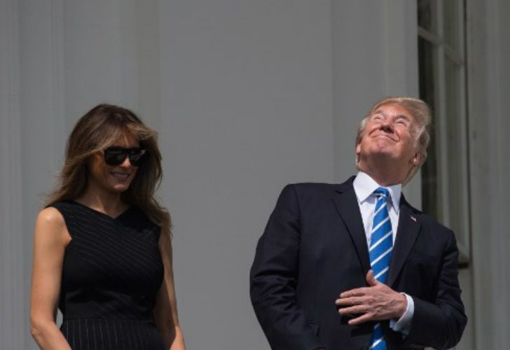 Donald Trump junto a su esposa Melania, también disfrutando del eclipse solar.