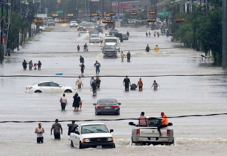 Como pueden, las personas escapan del desastre ambiental que provocó el huracán Harvey