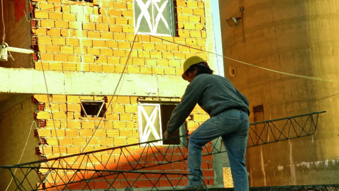 A construction worker carries building materials on a building site in the capital.