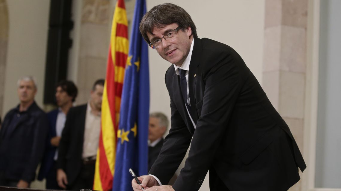 Catalan regional President Carles Puigdemont signs an independence declaration document after a parliamentary session in Barcelona.