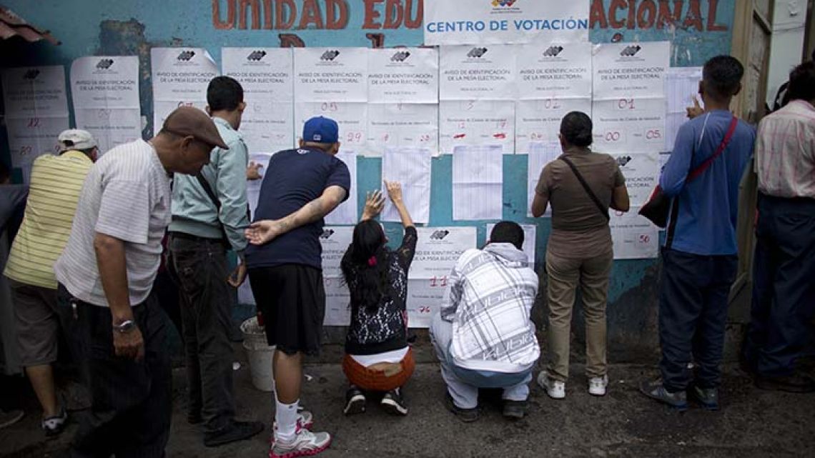 People look for their names on voter registration lists outside a polling station during regional elections in Caracas, Venezuela on Sunday.