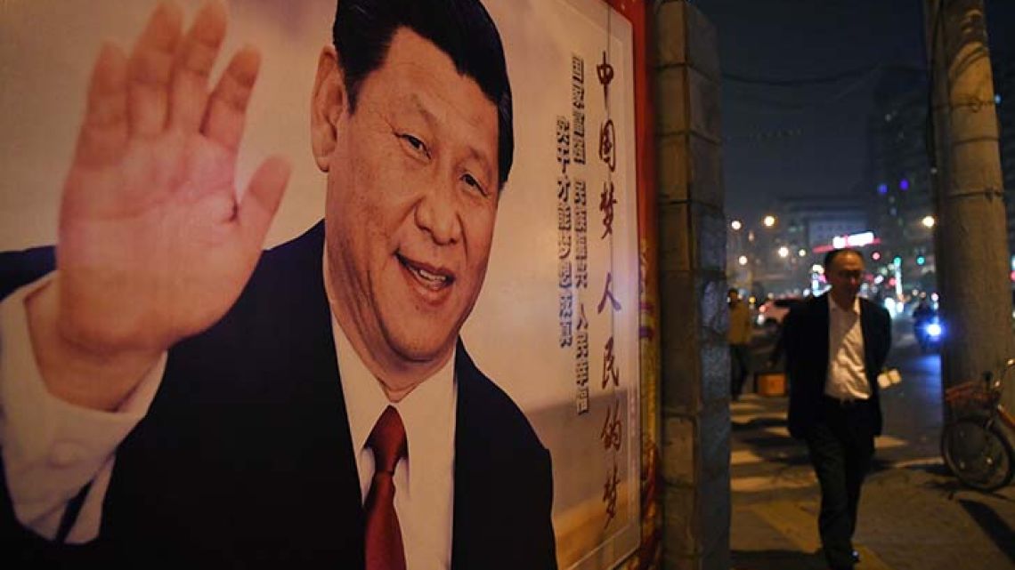 A man walks past a roadside poster of Chinese President Xi Jinping after the closing of the 19th Communist Party Congress in Beijing. Xi Jinping's name was added to the Communist Party's constitution at a defining congress, elevating him alongside Chairman Mao to the pantheon of the country's founding giants.