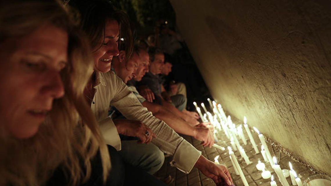 Locals place candles outside the Polytechnic School during a vigil in Rosario. Five victims killed in the bike path attack near the World Trade Center in New York were part of a group of friends celebrating the 30th anniversary of their graduation from the school in Rosario.