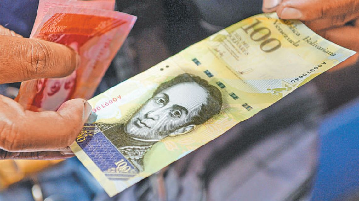 A man holds a new one hundred thousand-Bolivar-note in Caracas.