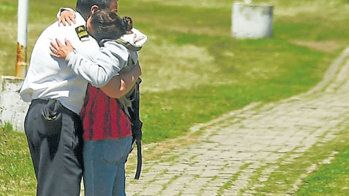 A relative and a comrade of one of the 44 crew members of the missing ARA San Juan submarine embrace each other in grief at the Navy base in Mar del Plata.