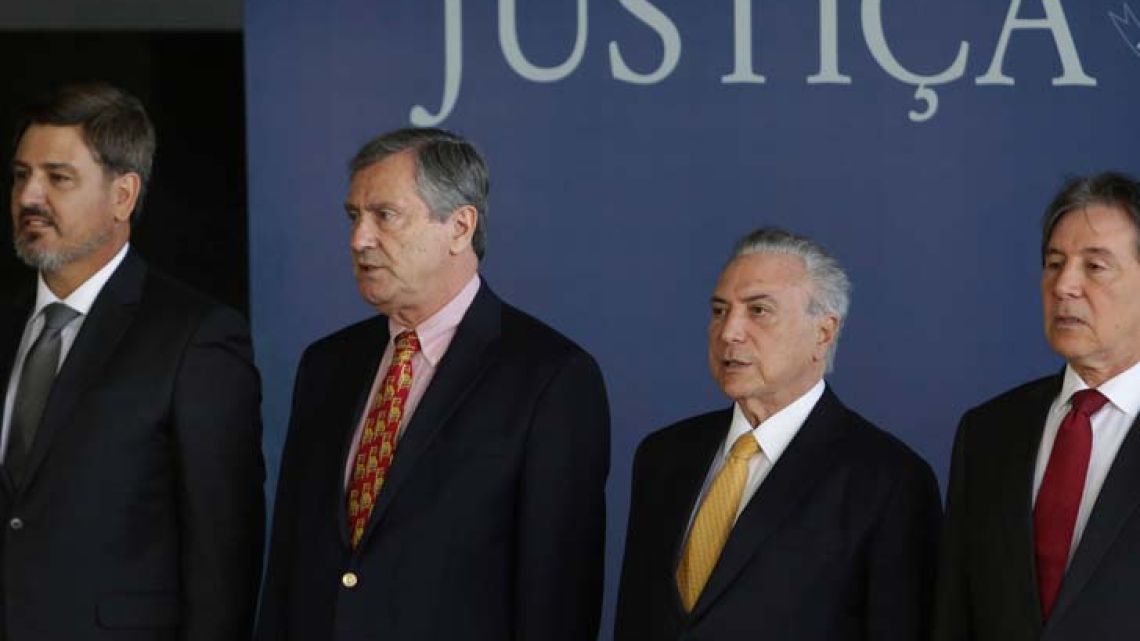 Brazil's President Michel Temer, second from right, accompanied by the President of the Senate Eunicio Oliveira, right, Minister of Justice Torquato Jardim, second from left, and the new Director-General of the Federal Police, Fernando Segovia, left, listen to Brazil's national anthem during Segovia's swearing-in ceremony in Brasilia on Monday.