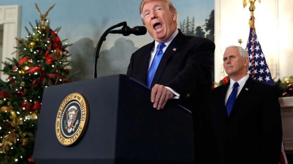US President Donald Trump speaks in the Diplomatic Reception Room of the White House on Wednesday. Trump recognized Jerusalem as Israel's capital despite intense Arab, Muslim and European opposition to a move that would upend decades of US policy and risk potentially violent protests. Vice-President Mike Pence listens on behind him.