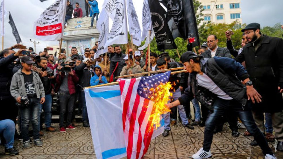 Manifestantes palestinos queman las banderas de EE. UU. e Israel en Gaza.