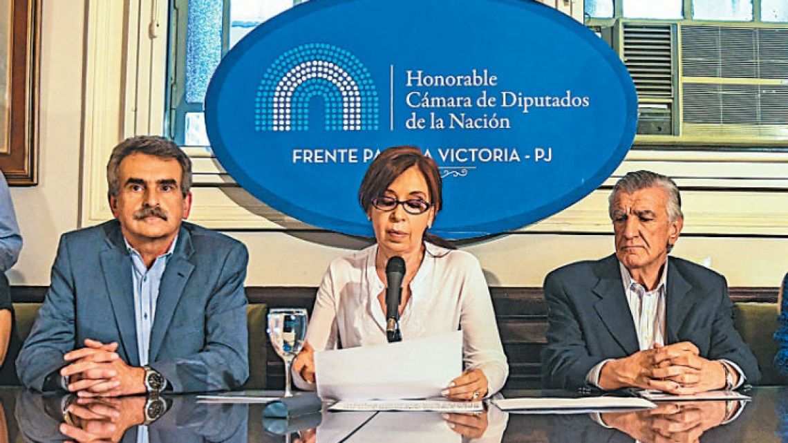 Cristina Fernández de Kirchner, flanked by Victory Front and Peronist lawmkers, delivers a speech at the Congress building to the press.