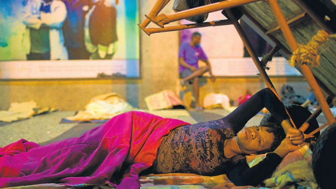 Silvana Regina Venceslão, 33, who has four children and is six month pregnant, rests outside the public defender’s office in Rio de Janeiro.