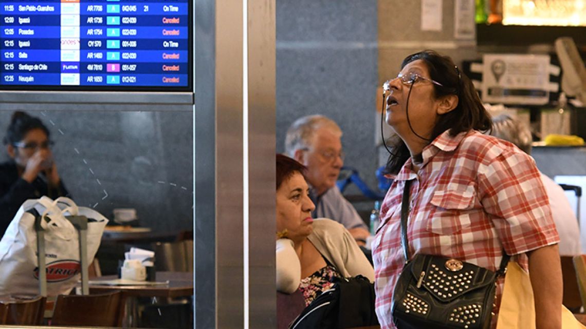 A lady checks the flight status board at Aeroparque airport in Buenos Aires as airlines Latam and Aerolineas Argentinas, adhering to a December 2017 general strike, go about reprogramming flights.