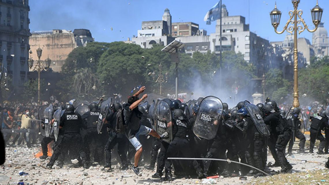 Riot police clash with demonstrators protesting against proposed pension reforms outside the National Congress.