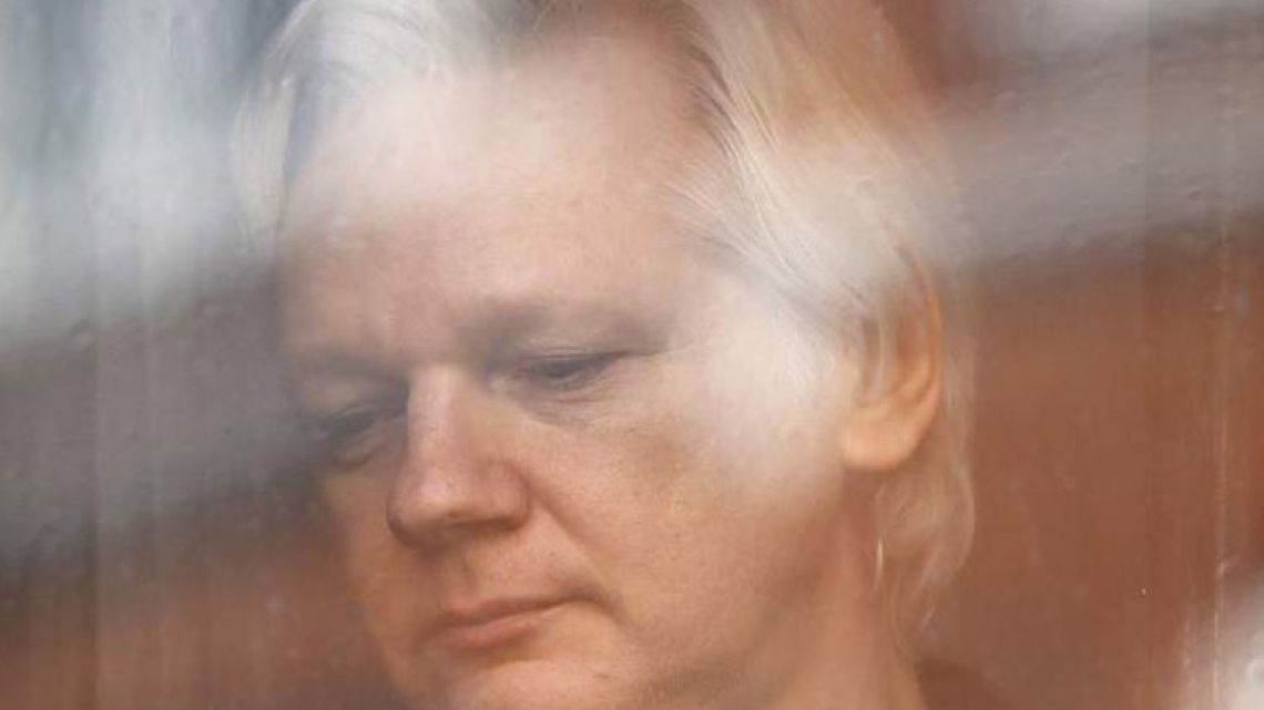 Julian Assange looks out the window from the Ecuadorean embassy in London in this file photograph.